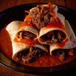 Burrito de carne de porco com molho vermelho defumado